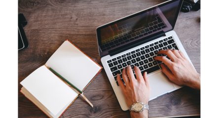 A laptop, notebook and hands 