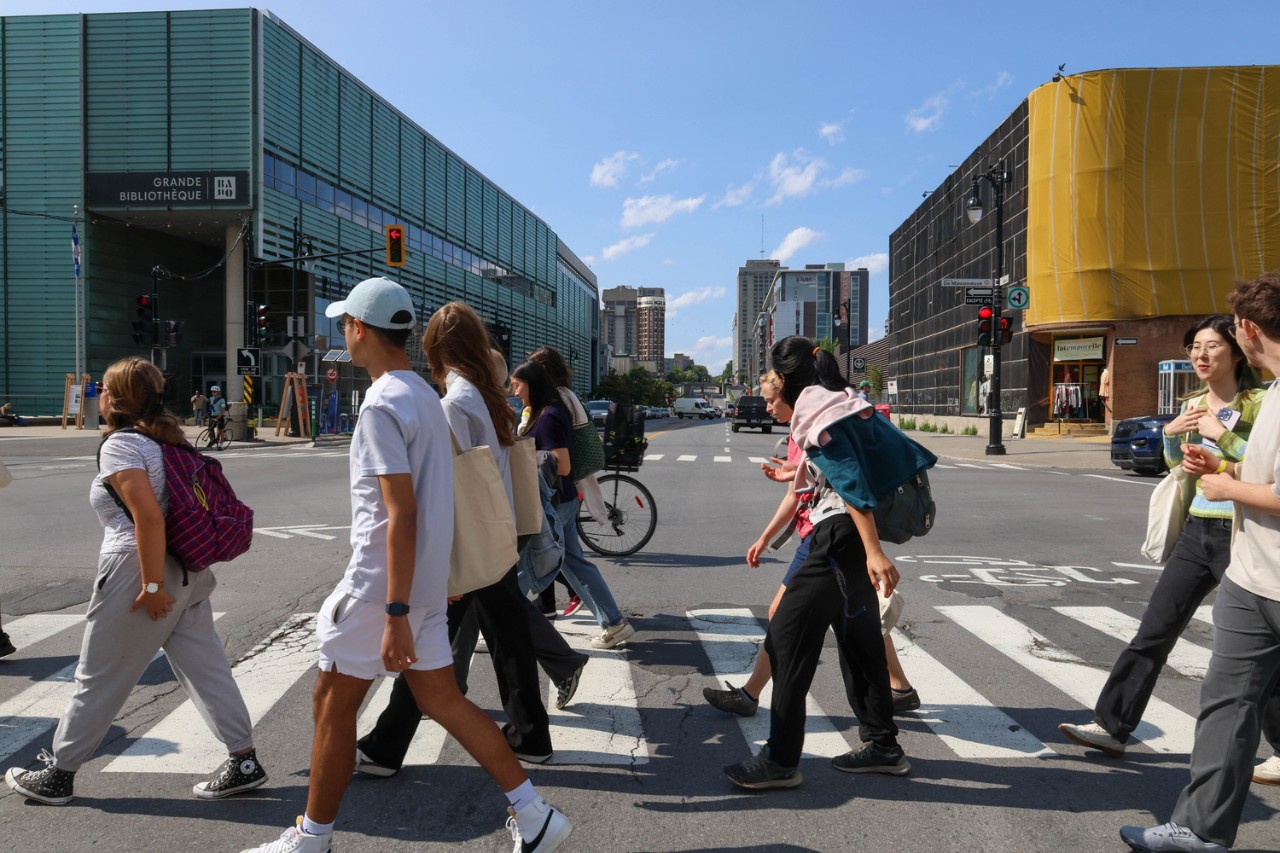 Students crossing the street in front of the Grande Bibliothèque of the Bibliothèque et Archives nationales du Québec (BAnQ) in Montréal.