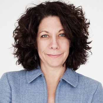 Headshot of woman wearing light-blue tweed blazer