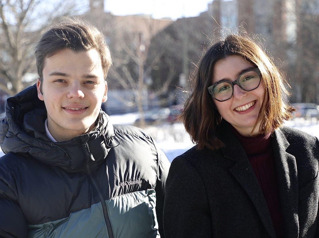 Lytvynenko (left) and Kliot pose on a bench outside the Loyola campus. Winter landscape.