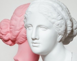Classical busts of two women talking to each other. The left-side woman is rose-coloured, the right-side woman is white.