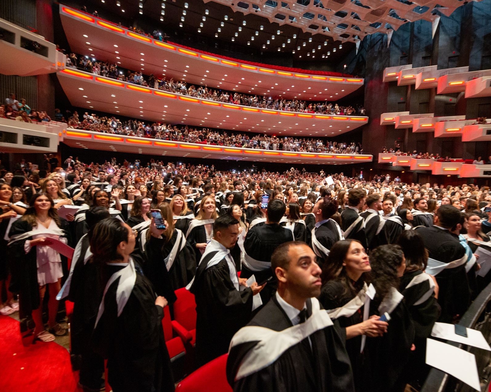 A crowd of newly graduated students, dressed up for Conovcation, filling up the room at Salle Wilfrid Pelletier