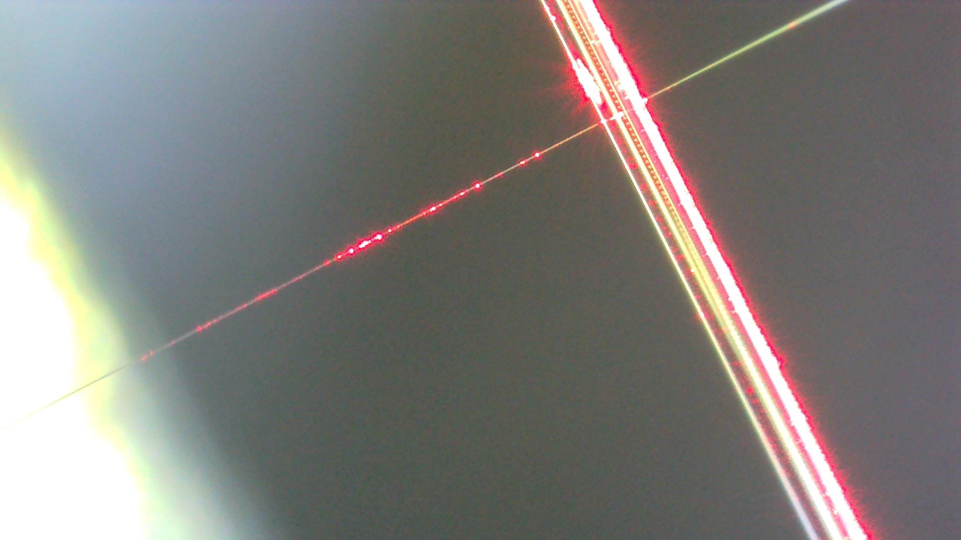Micro-resonators are small optical devices designed to trap light. To guide light into these devices, we use a taper—an optical fiber that’s been stretched so thin it’s almost invisible to the naked eye. In the image, the thin fiber shown is the taper. Perpendicular to the taper is a micro-resonator made of optical fiber, with a diameter of 125 µm.