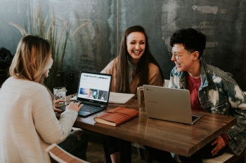 Stock photo of three women at table with laptops