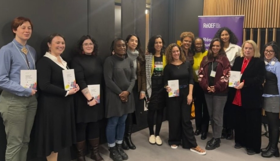 Thirteen book contributors smile toward the camera holding copies of the book Décentrer le féminisme blanc : luttes et enjeux actuels