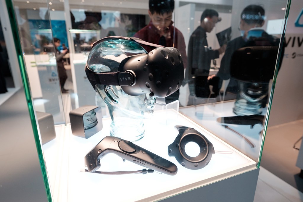 A VR headset and controller inside a glass display case