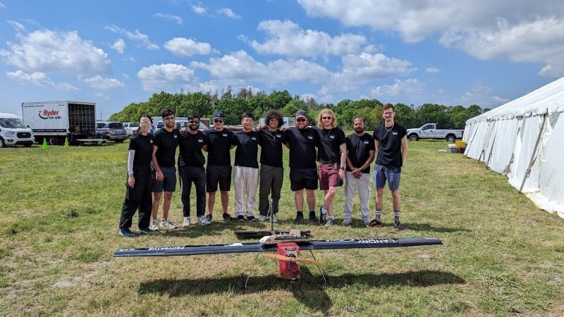 SAE Concordia team stands together in front of their primary aircraft.