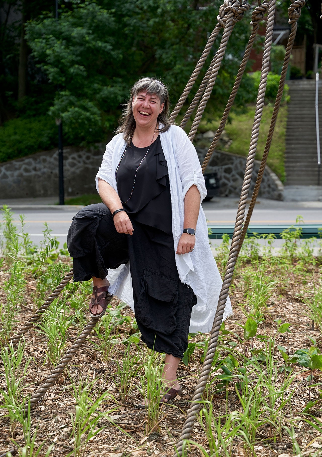 Artist Nadia Myre standing alongside her sculpture Nouée