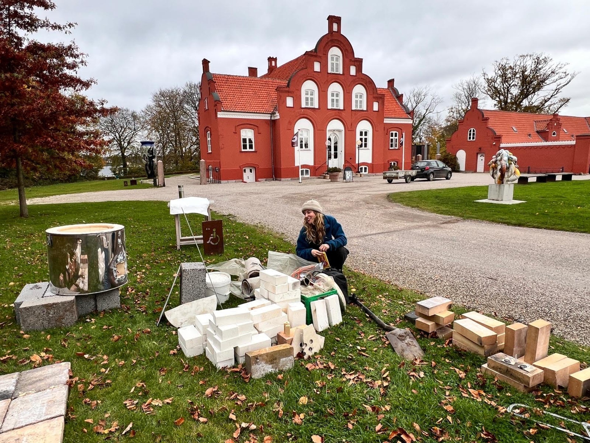 Teresa Dorey at the Clay Museum in Denmark during the Genjord Sustainability Symposium Clay Museum in Denmark, woman constructing a rocket kiln