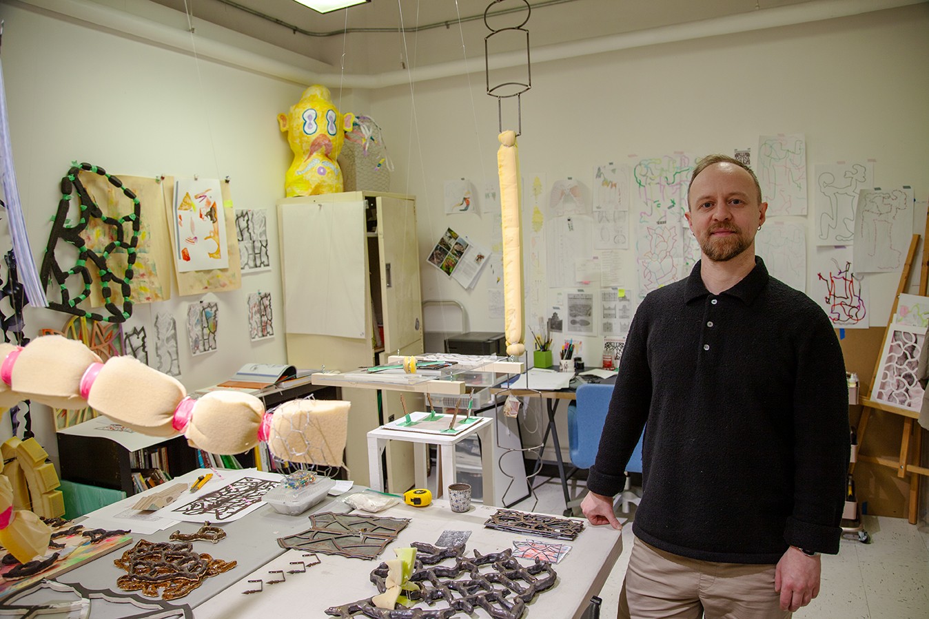 Picture of man artist in studio with solorful materials (including fibres)