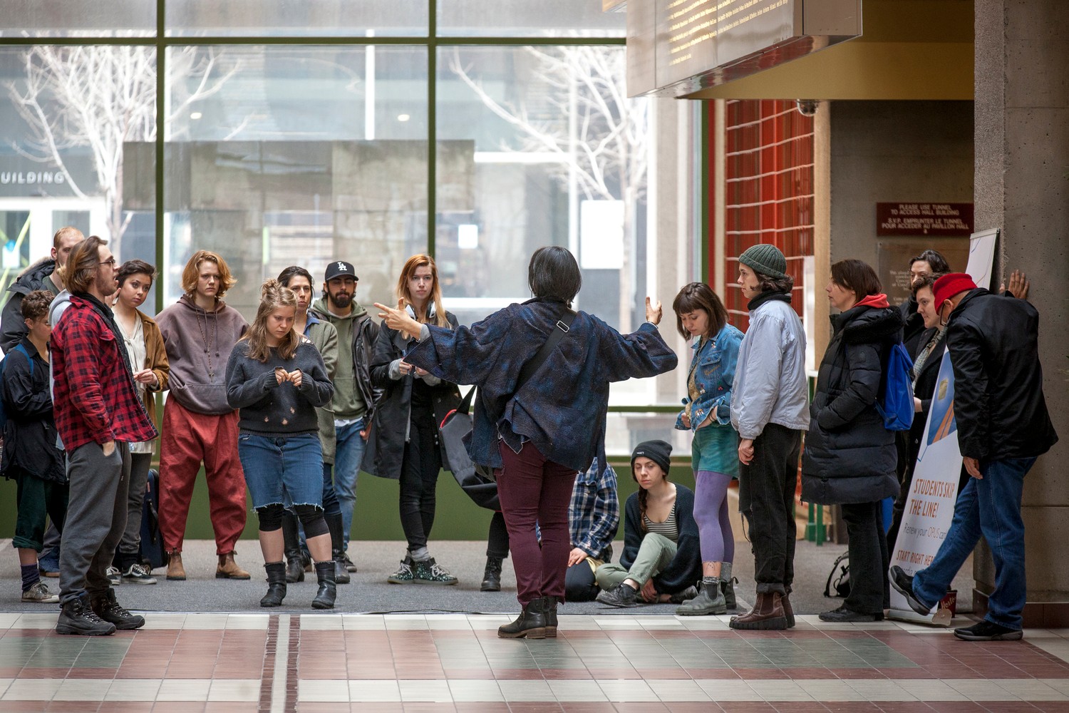 Group of young people in hall with professor