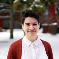 Jess Stewart-Lee Smiling person with white buttoned shirt and red cardigan
