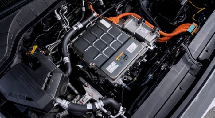 Hyundai KONA EV Motor An electric motor seen under the hood of a car.