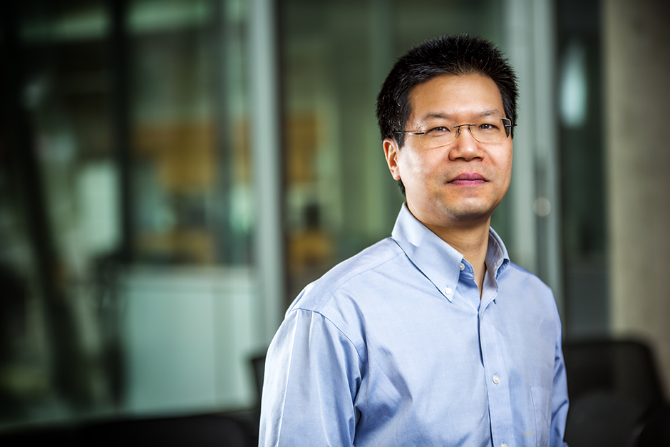 Zhibin Ye, professor in the Department of Chemical and Materials Engineering at Concordia's Gina Cody School, wearing glasses and a light blue button-down shirt, standing in a modern research facility.