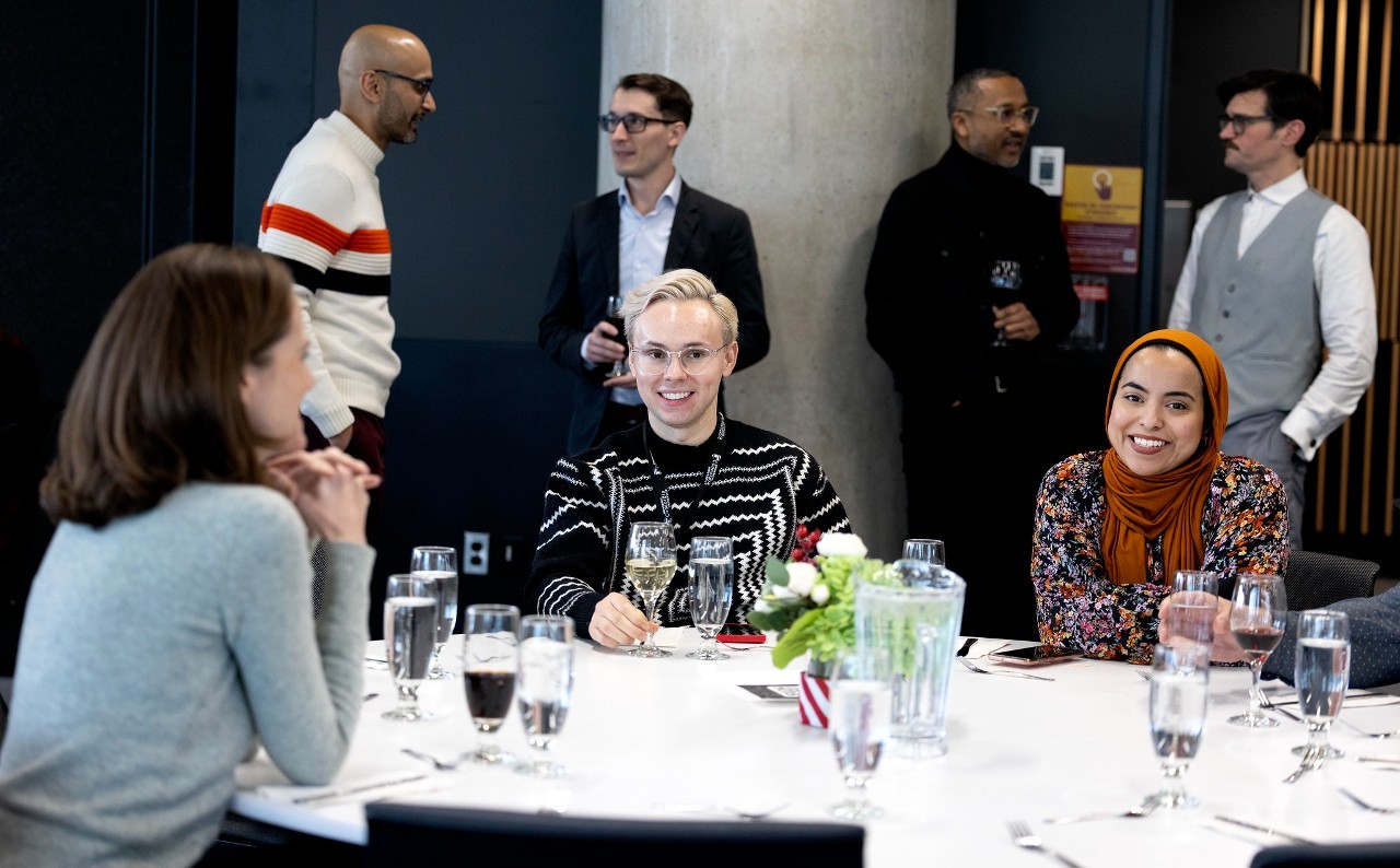 Smiling staff pose at a table during the 2023 Dean's Awards