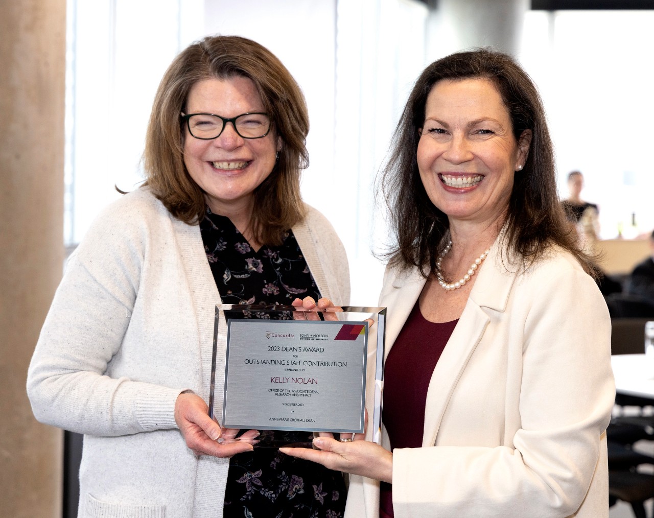 Kelly Nolan accepts her Outstanding Staff Contribution Award alongside Dean Anne-Marie Croteau