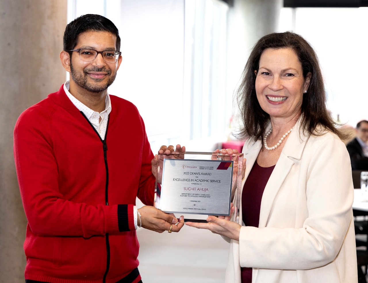 Suchit Ahuja accepts his award for Academic Service alongside Dean Anne-Marie Croteau