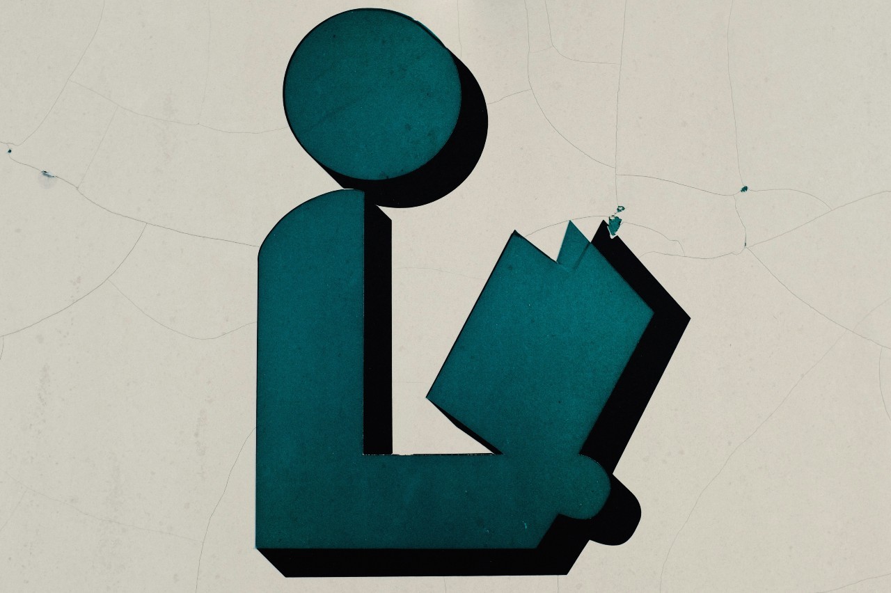 graphic of a stick figure holding an open book