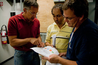 Lopes (left), SBRN Director Andreas Athienitis and electrician Alain Aubé (right) prepare to install a new programmable inverter into the MB Building solar panel system. Lopes is working with a group of grad students using the new hardware to test the system’s maximum power capacities.