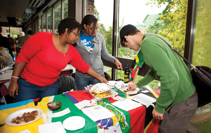Jasmine Dixon (right) and Karleen Julient (centre) of the Concordia Caribbean Student Union share fried plantains, Jamaican patties, and cassava bread and tamarind dip.