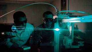 Khalid Koraitem (left) and Percy Graham, mechanical and industrial engineering master’s students working with Dolatabadi, demonstrate a nozzle attachment similar to his proposed design. Lasers are used to measure the particulate movement.Concordia University