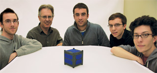 Space Concordia members (left to right) Corey Clayton, Scott Gleason, Niccolo Cymbalist, Nick Sweet and Zak Kain show a model of Space Concordia’s CubeSat project. To get into space, the CubeSat cannot propel itself. Rather, it ‘piggybacks’ upon a larger satellitebeing launched. Once there, the CubeSat releases from the satellite and proceeds to perform its function. The what, where, and when of the larger satellite launch for the Canadian Satellite Design Challenge has not yet been determined. | Photo by Concordia University