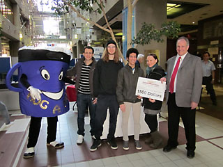 The R4 team, mascot Huggy da Muggy, Daniel Kielback (Loyola Compost Coordinator), Ramy Ghaly, Faisal Shennib (Environmental Coordinator) and Diana Kirkwood receive a donation from Daniel Houde, Director of Campus Retail Stores. | Photos by Kim Barbier