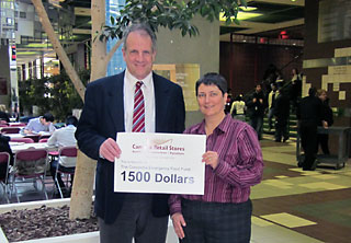 Daniel Houde gives Rev. Ellie Hummel of the Multi-Faith Chaplaincy a cheque for the Student Emergency and Food Fund.