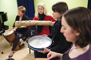 Sandi Curtis (playing drum at left), a professor in the Department of Creative Arts Therapies, studies how music therapy improves lives. | Photo courtesy of Sandi Curtis