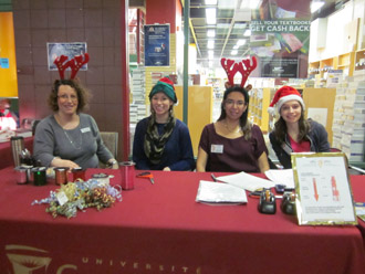 Pina Greco, event coordinator in Enrolment Services (on left) greets holiday shoppers. She is joined by three of the many student volunteers.