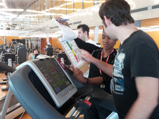 David points to the Borg’s Scale while on the cardio machine.