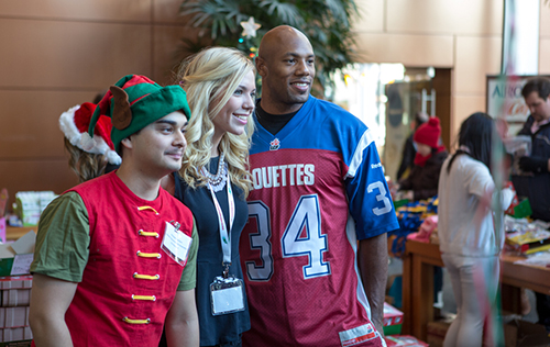 Christophe Lambert, VP Decision Sciences Student Association, and Kourtney De Perno, VP Marketing, DSSA, pose with Kyries Hebert, professional safety/linebacker for the Montreal Alouettes.