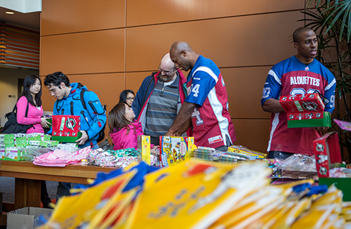 Hebert and Chima Ihekwoaba, defensive end for the Alouettes, explain how the charity works to passersby.