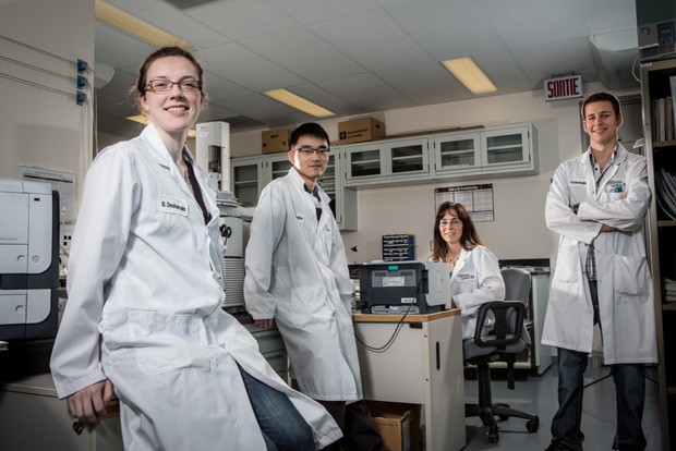 Concordia students Brigitte Desharnais, Kevin Louie and Maxime Gosselin with their supervisor Martine Lamarche (seated), at the Laboratoire de sciences judiciaires et de médecine légale 