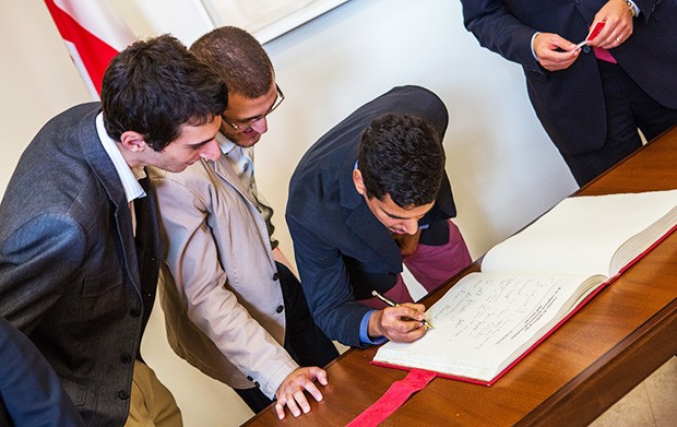 Left to right: Sami Sayegh, Charles Gedeon and Al-Hurr Al-Dalli sign the Livre d’or.