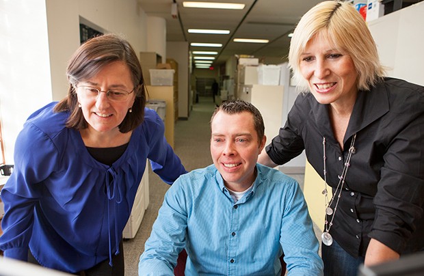 Marie-Claire Newman, David Dedeyne and Dina Carosielli review training material on the new Student Information System.