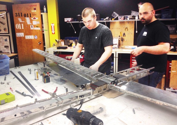 Concordia SAE AeroDesign teammates assemble a regular class aircraft in the B Annex basement workshop.