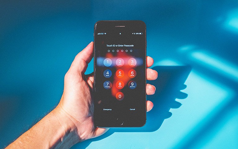 Image of a hand holding a black iphone.