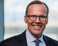 Older man with glasses wearing a suit.