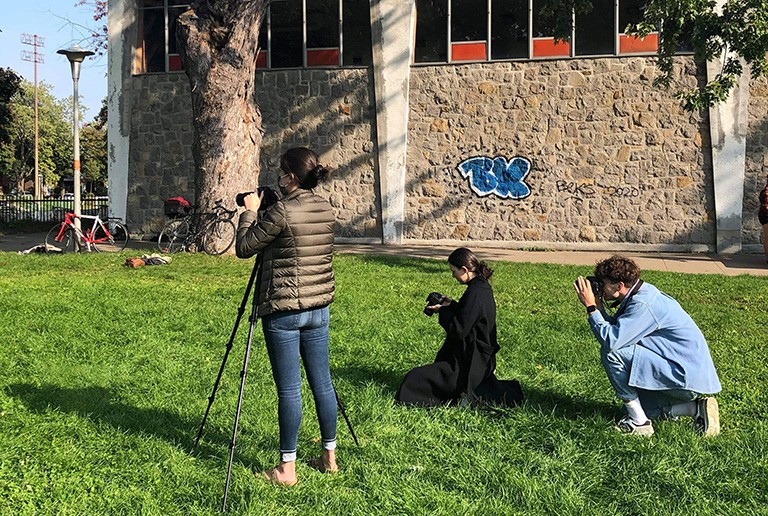 Three people, each with a camera, taking a photo of someone outside the picture frame.