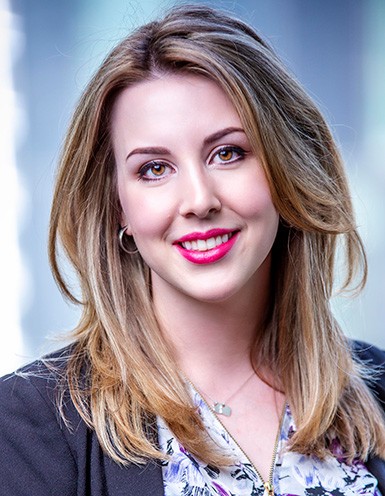 Young woman with long blonde hair and bright pink lipstick.