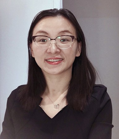 Young woman with long dark hair and glasses.