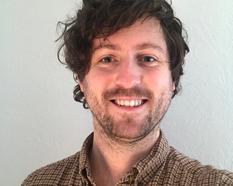 Patrick Brodie headshot of smiling man wearing collared shirt