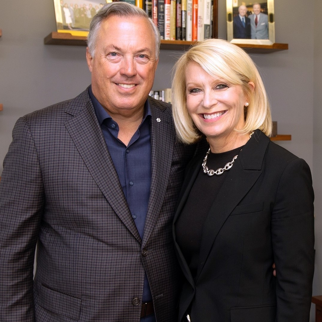 Man and woman standing close beside each other dressed in business attire