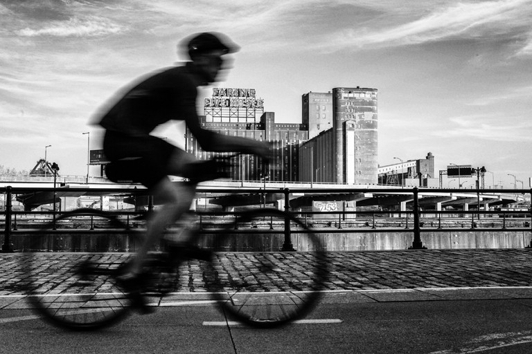 A cyclist biking on a city bike path.