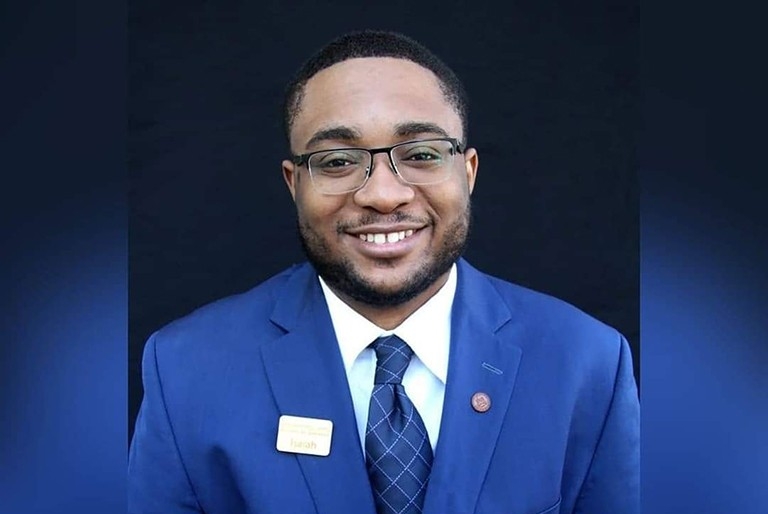 Isaiah Joyner Smiling woman wearing dark glasses, blue blazer, white short and blue tie