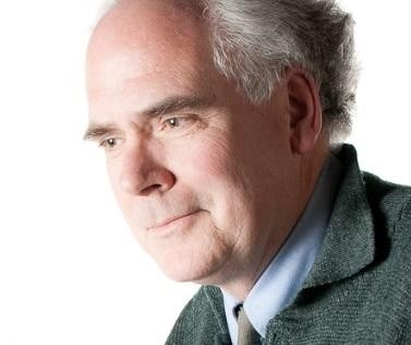 Smiling man wearing dark blazer and blue button-up shirt