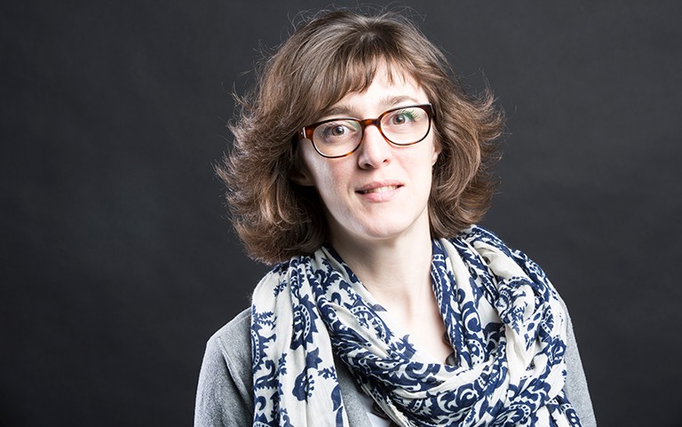 Women with long, feathered hair, glasses and a patterned fabric scarf.