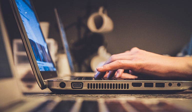 A side view of someone using a laptop