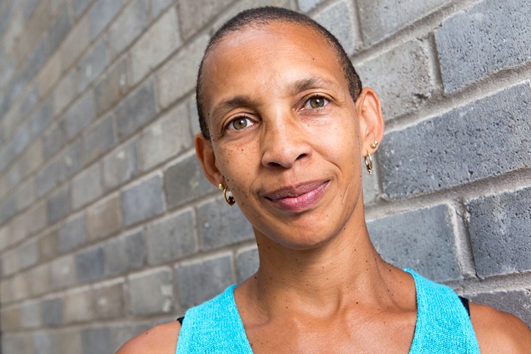 Angélique Willkie: “Being appointed to lead university-wide efforts to address systemic anti-Black racism is a historic undertaking that I don’t take lightly.” Smiling Black women with short hair, green eyes and a turquoise singlet.